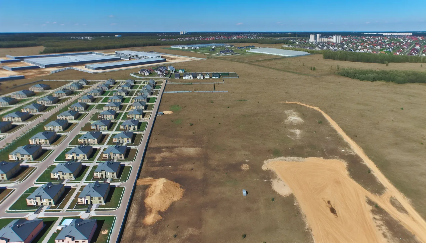 Aerial view of undeveloped land next to new construction